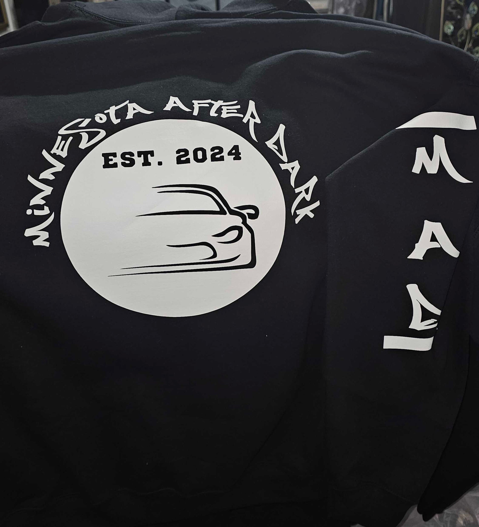 Black sweatshirt with 'Minnesota After Dark' logo and text on a dark background