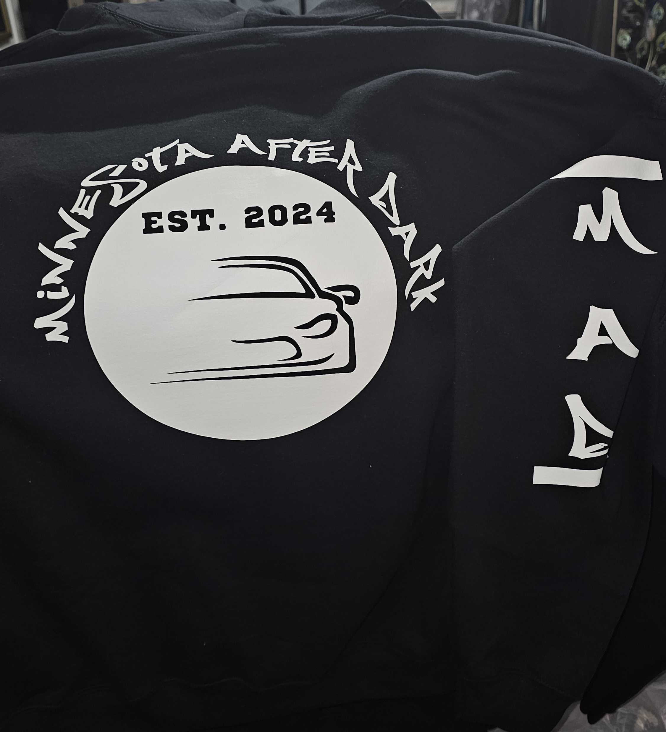 Black sweatshirt with 'Minnesota After Dark' logo and text on a dark background